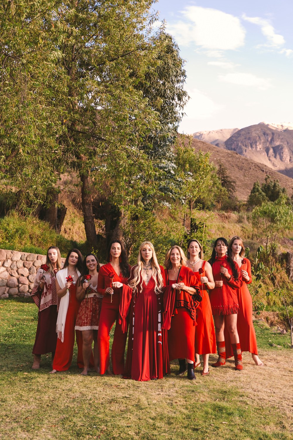 Roda de mulheres reunidas em celebração, segurando rosas nos Andes peruanos
